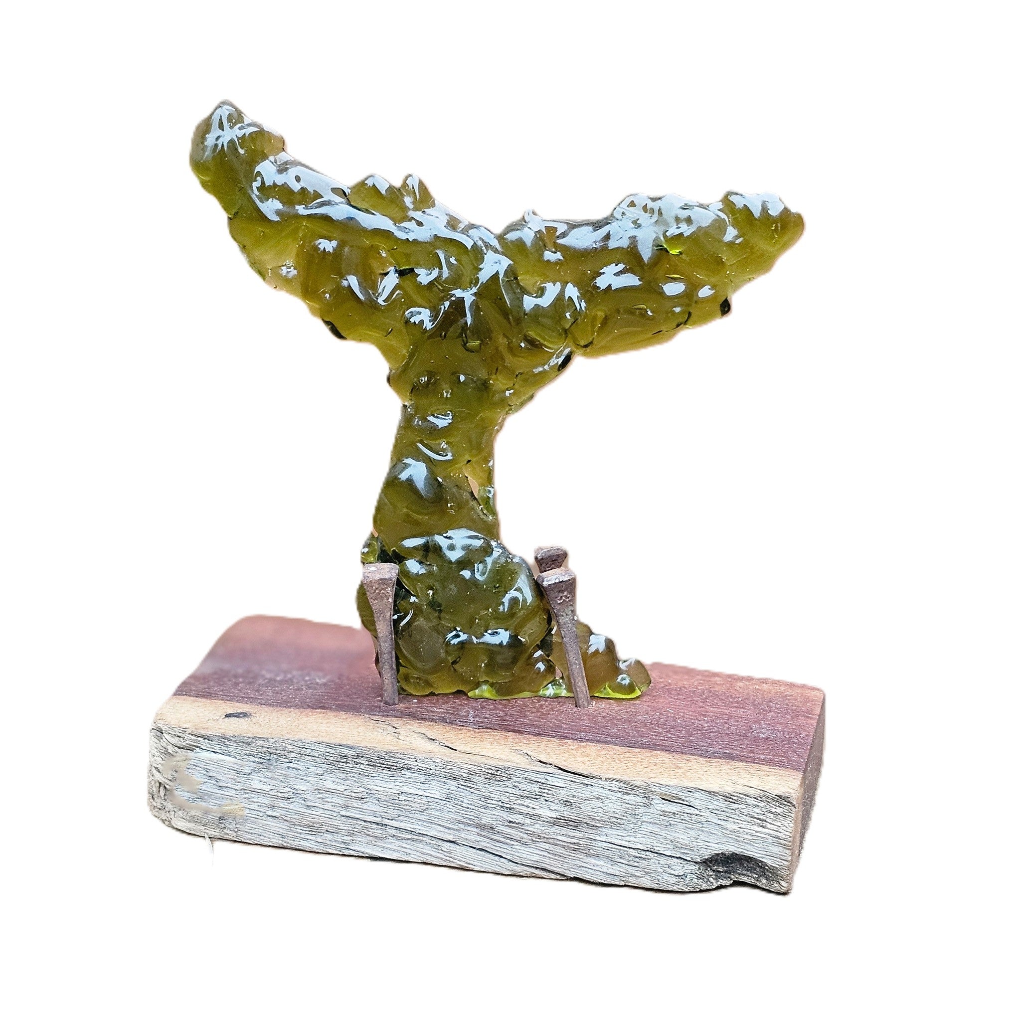 A decorative upright glass whale tail sculpture with glossy Kelp-olive-green colour, mounted on a rectangular wood base, photographed on a plain white background.