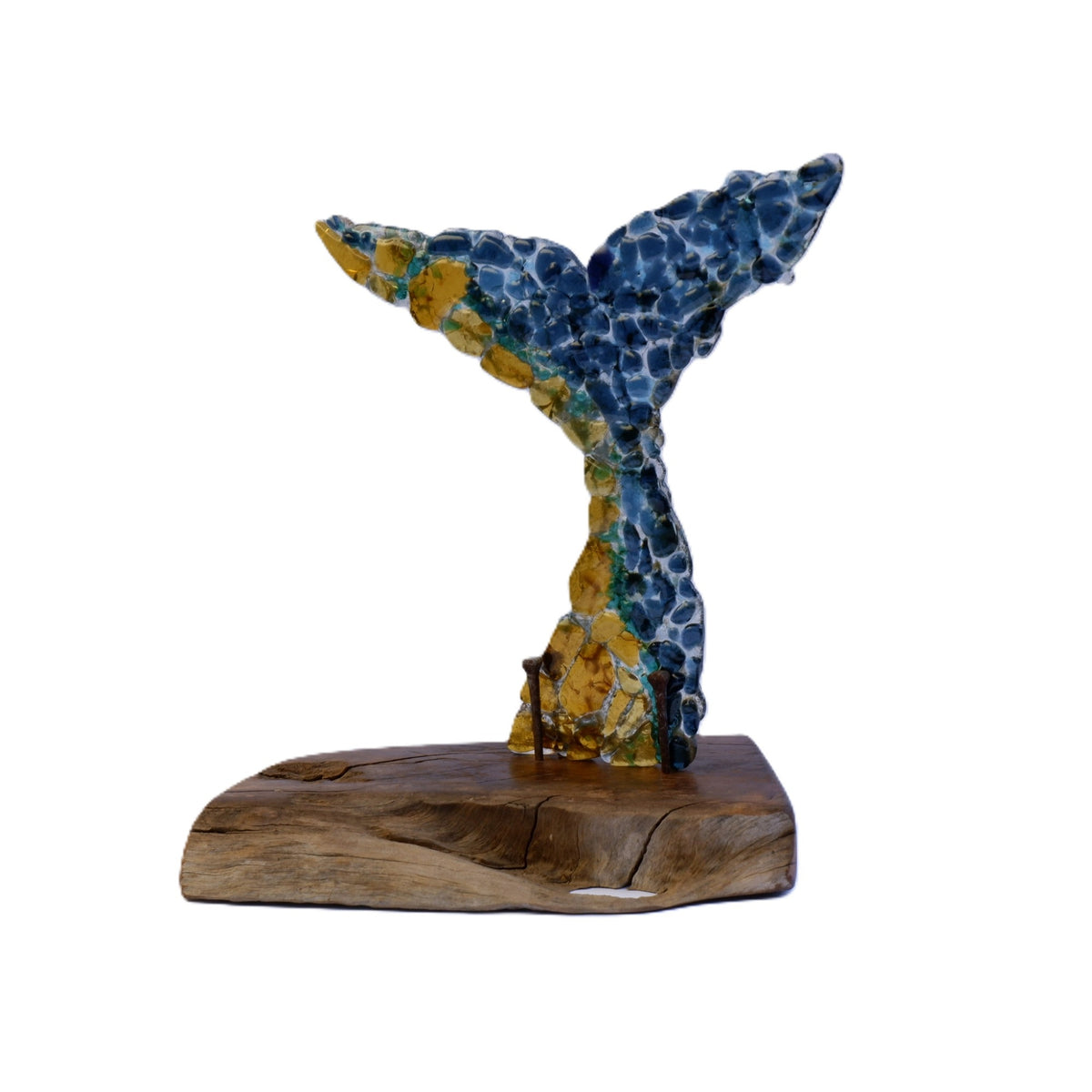 A decorative fused art glass sculpture shaped like a whale tail, featuring a mottled blue and yellow textured body mounted on an oiled Australian Bush brown wooden base, supported with aged nails. Sculpture shown against a plain white background.