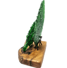 Side view of two fused green glass leaf sculptures displayed on a single oiled piece of Australian Bush timber with natural wood grain, supported by aged metal nails and isolated on a white background.
